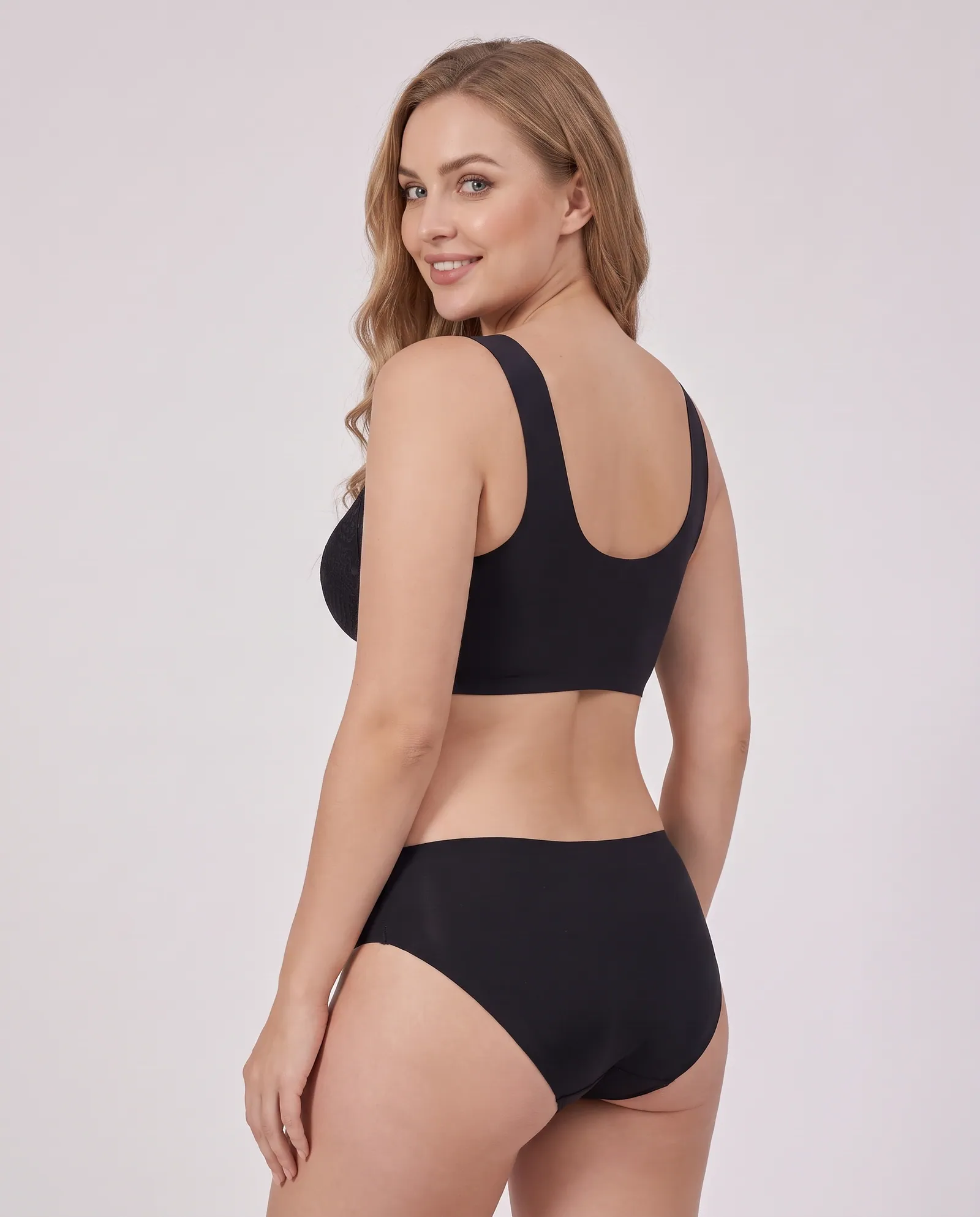 The Flatterer Bra in Black, back view on model showing the smooth wide back band
