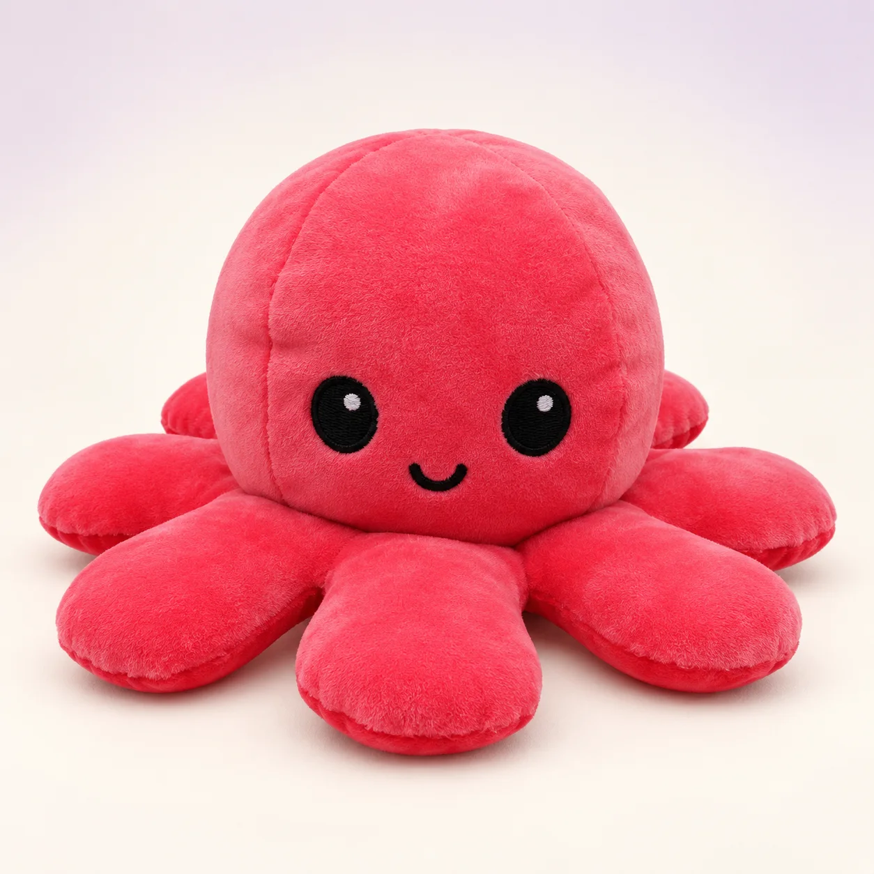 Pink reversible octopus plush showing its smiling face